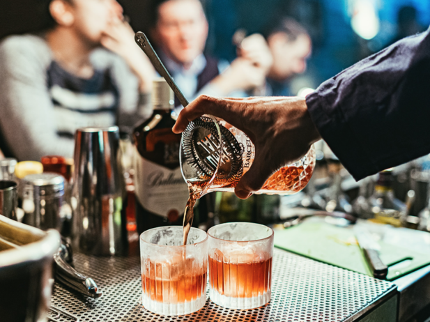a bartender pours cocktails