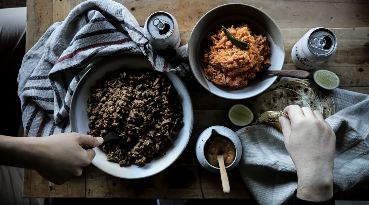 hands reaching for taco fillings at la taqueria