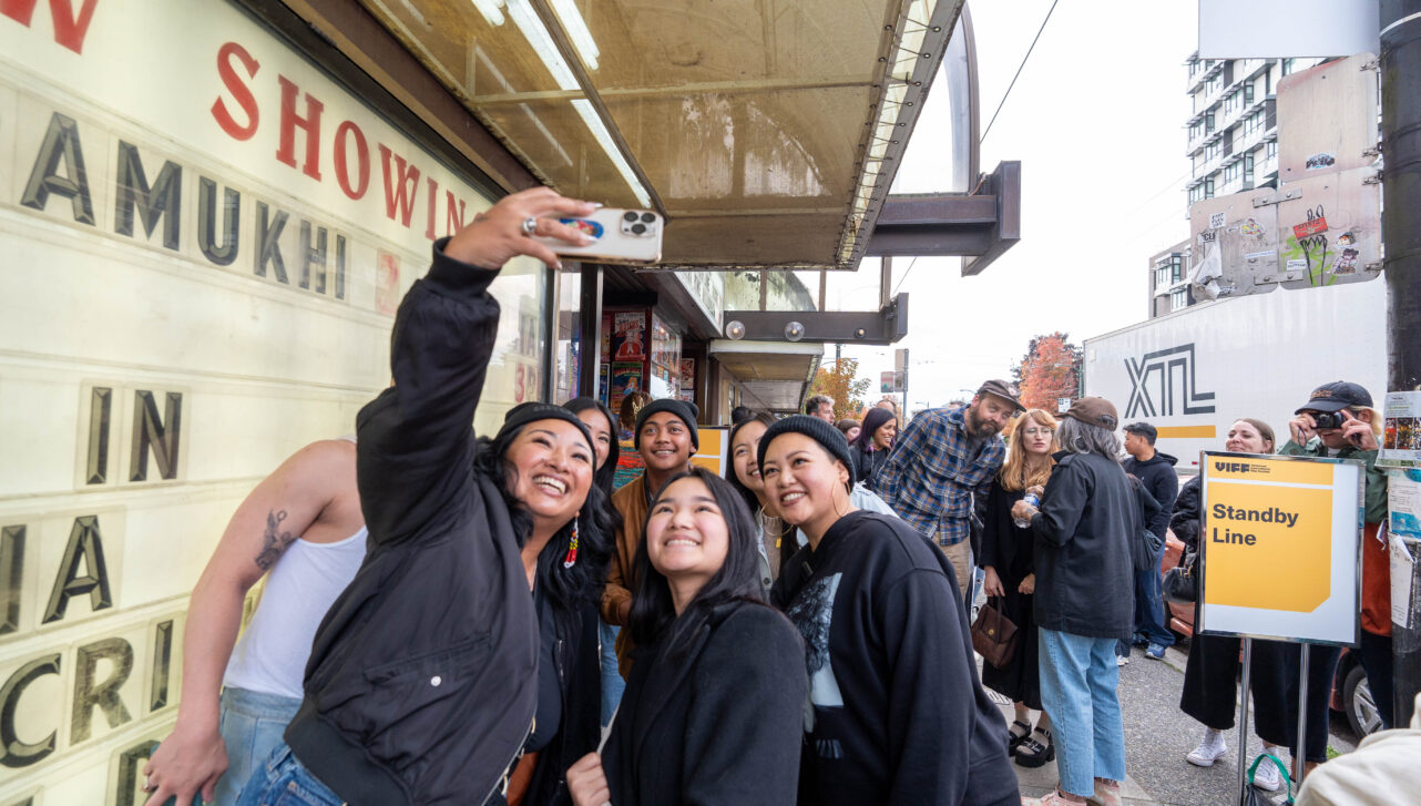 Group of people taking a selfie infront of a theatre