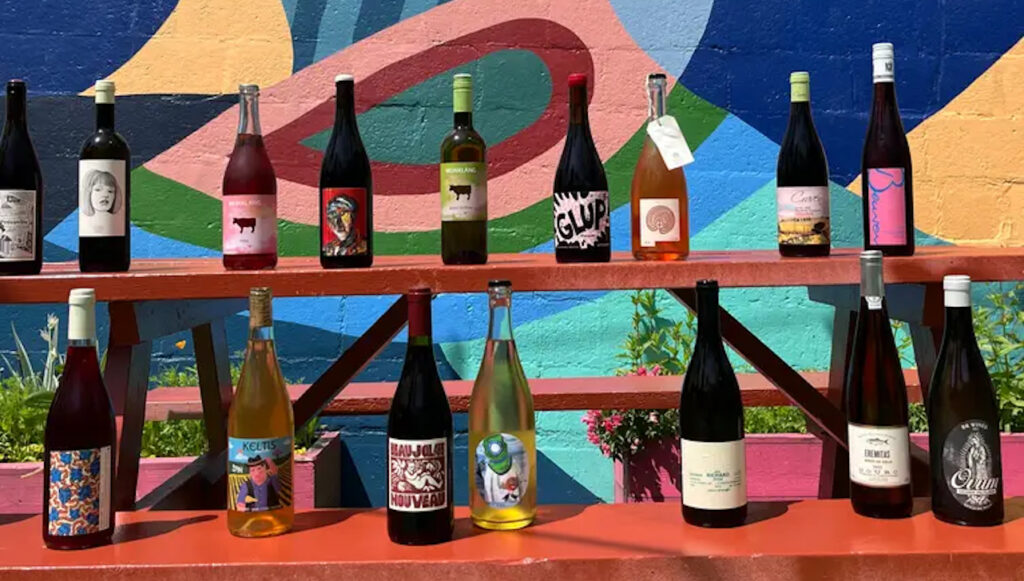 Bottles of natural wines perched on a picnic bench at Grape Vibes