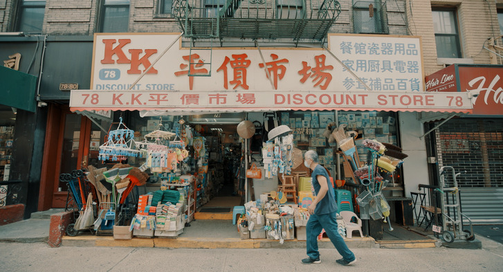 A still from the documentary, a man walks through a chinatown street in NYC.
