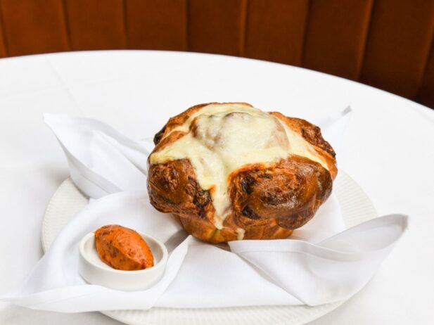 loaf of cheesy brioche on a plate with sun-dried tomato butter