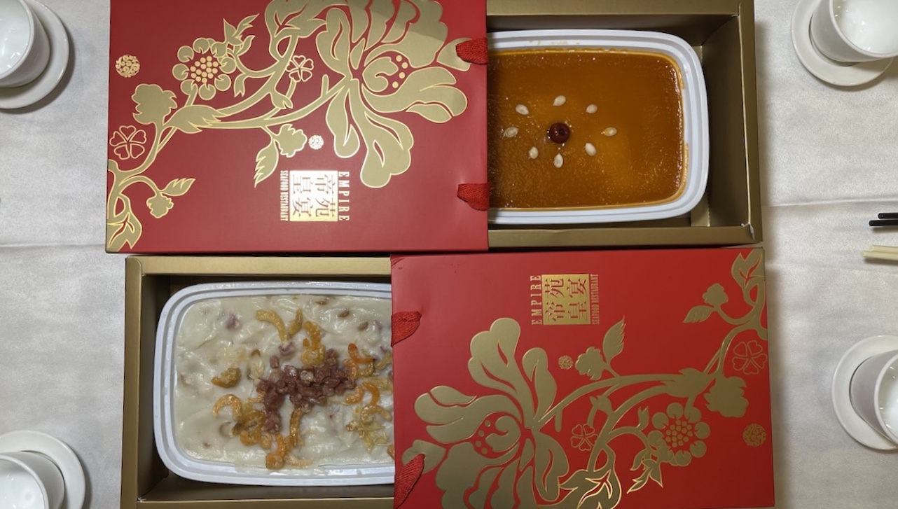 A box of new year pudding and a box of turnip pudding against each other, surrounded by teacups. 