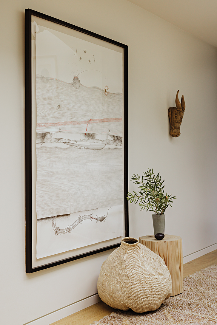 a large drawing hangs on the wall in a black frame