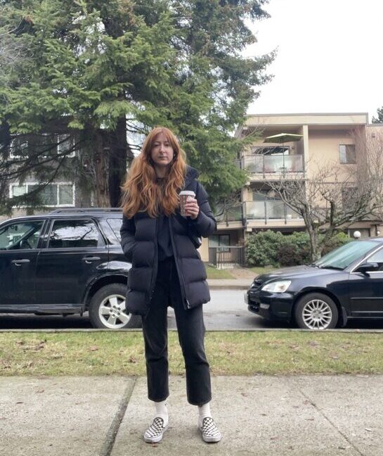 Author outside holding starbucks coffee cup and wearing black puff jacket