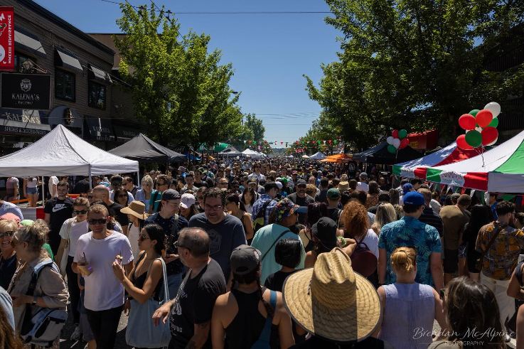 a crowd of people walking down commercial drive