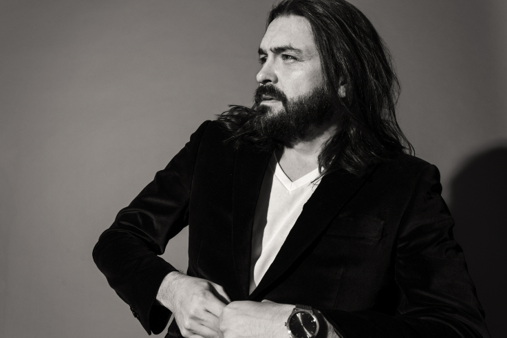 black and white photo of an actor on a grey background looking into the distance