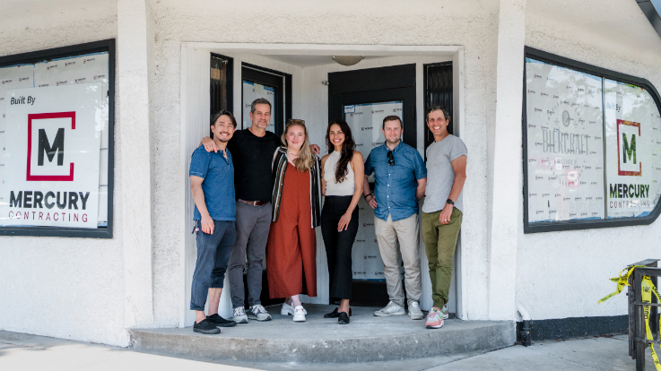 a group of people gathered on the stoop of an under-construction restaurant