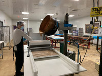 Machine distributing hot caramel into trays