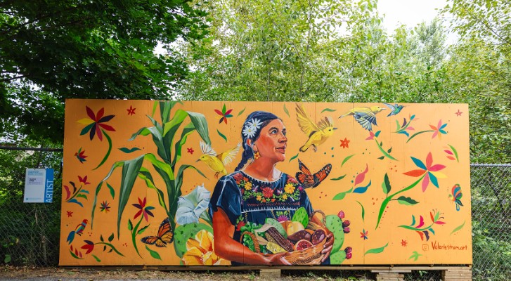 A mural showing a older indigenous woman surrounded by nature 