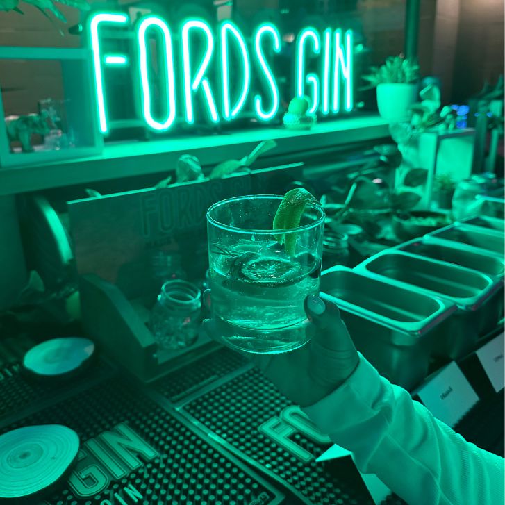 Gin and Tonic in front of a neon Fords Gin sign