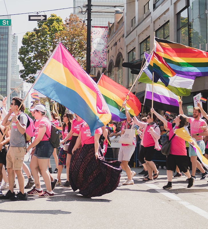 A mass of rainbow flags during a pride parade on Robson Street in Vancouver
