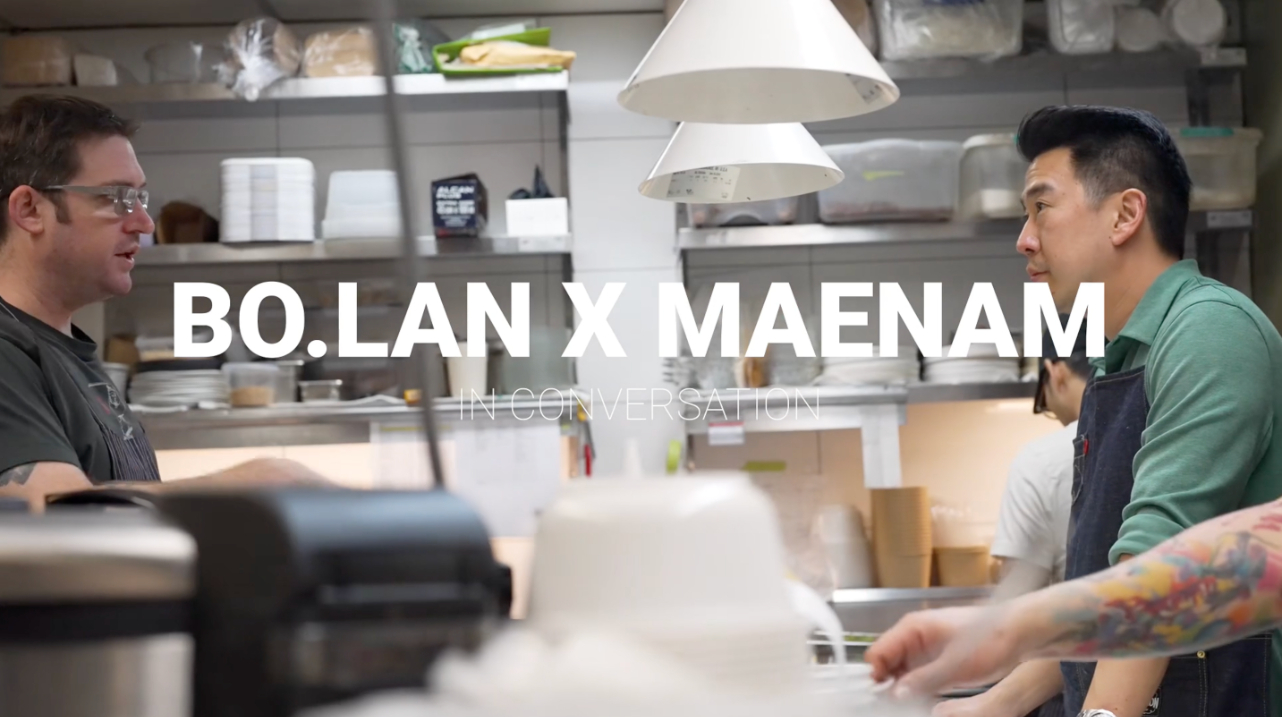 maenam chef angus an and the chef of bo.lan look at each other across a busy kitchen in a screenshot from a video