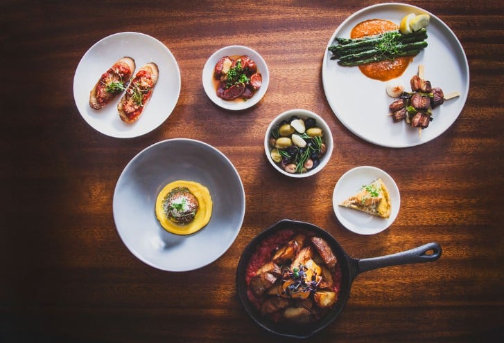 An assortment of small dishes, including asparagus, bruschetta and an assortment of olives
