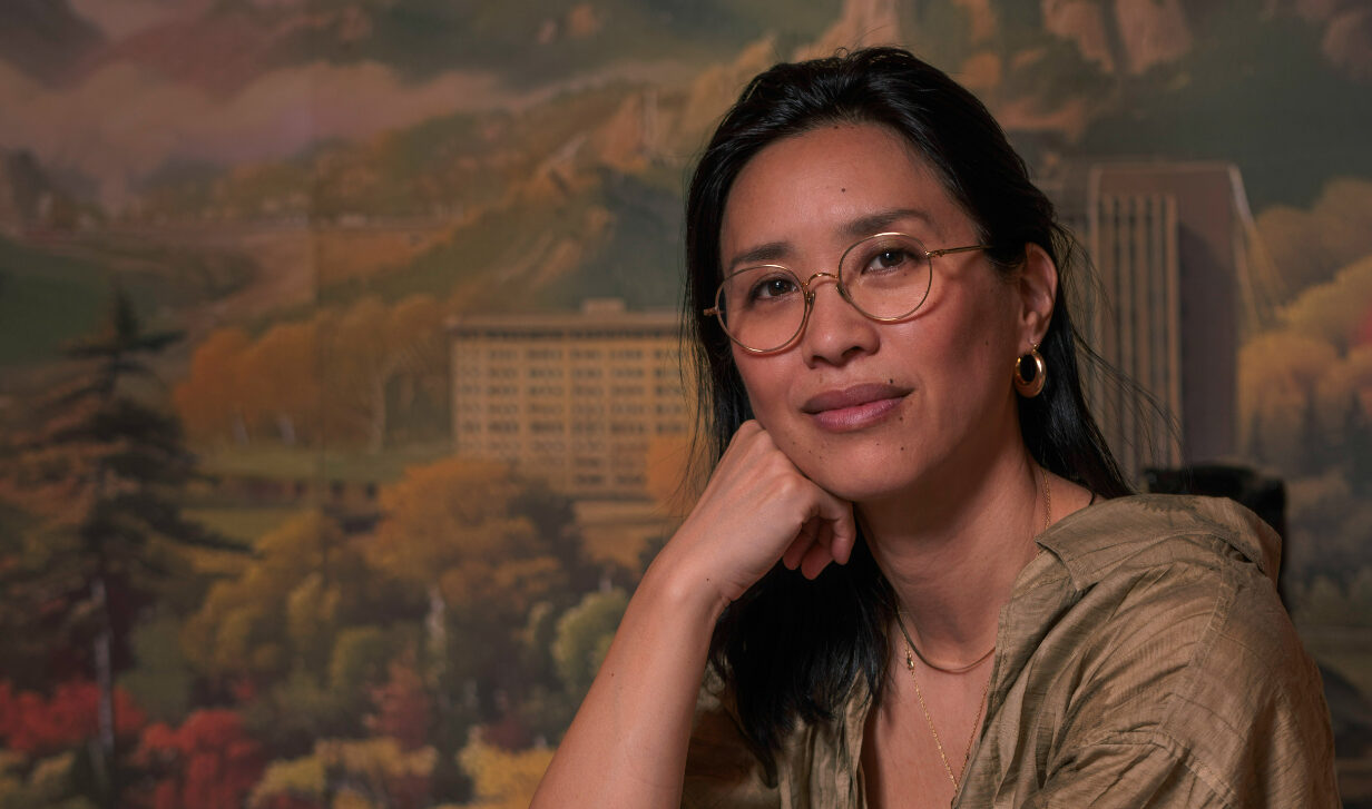 tannis ling sits at table in front of mural