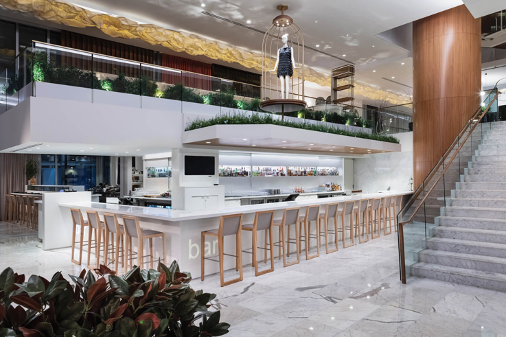 a glamorous modern bar with stools in a hotel lobby