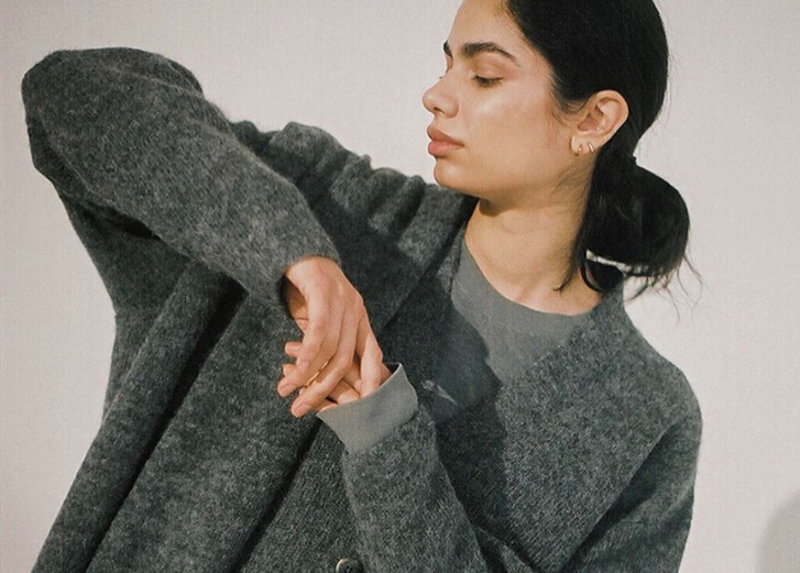 Brown haired girl wearing grey sweater. 