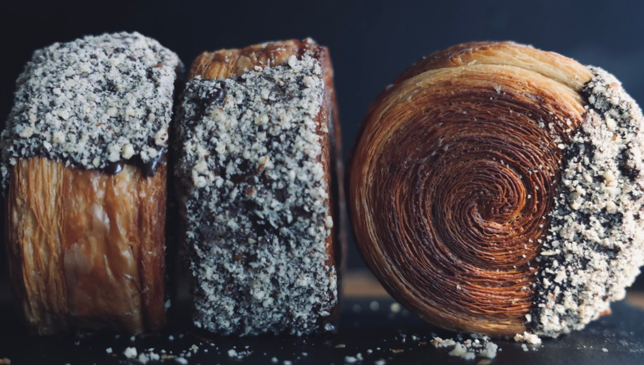 Three round croissants, black background.