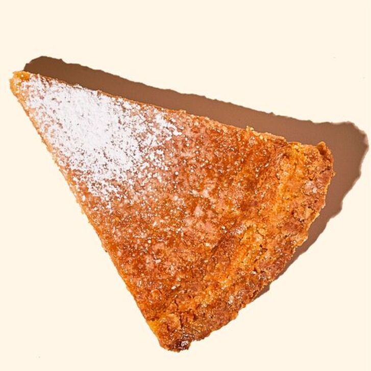 Single slice pumpkin pie with powdered sugar dusted on 