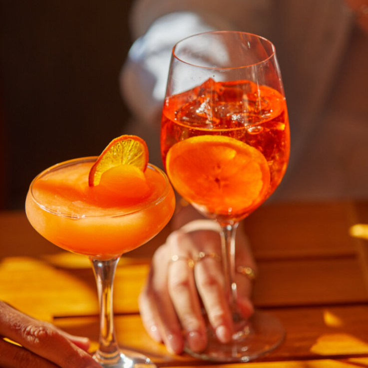 two orange cocktails on a table