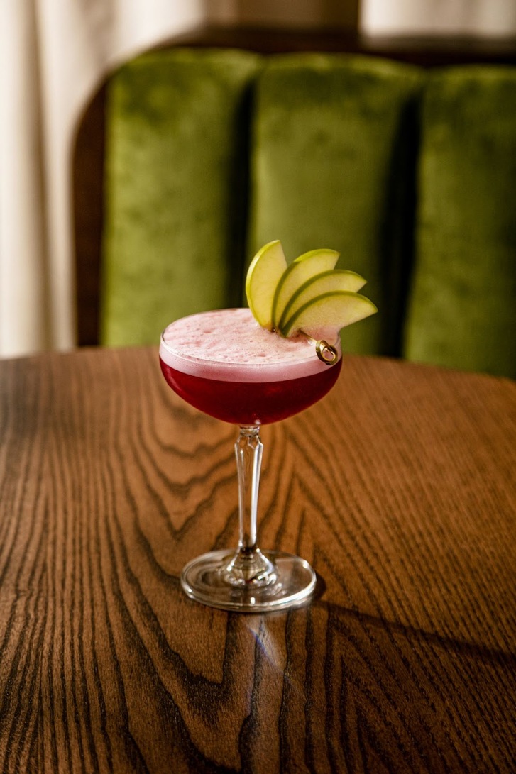 Same image as featured. Cocktail glass full of red foamy liquid with pear