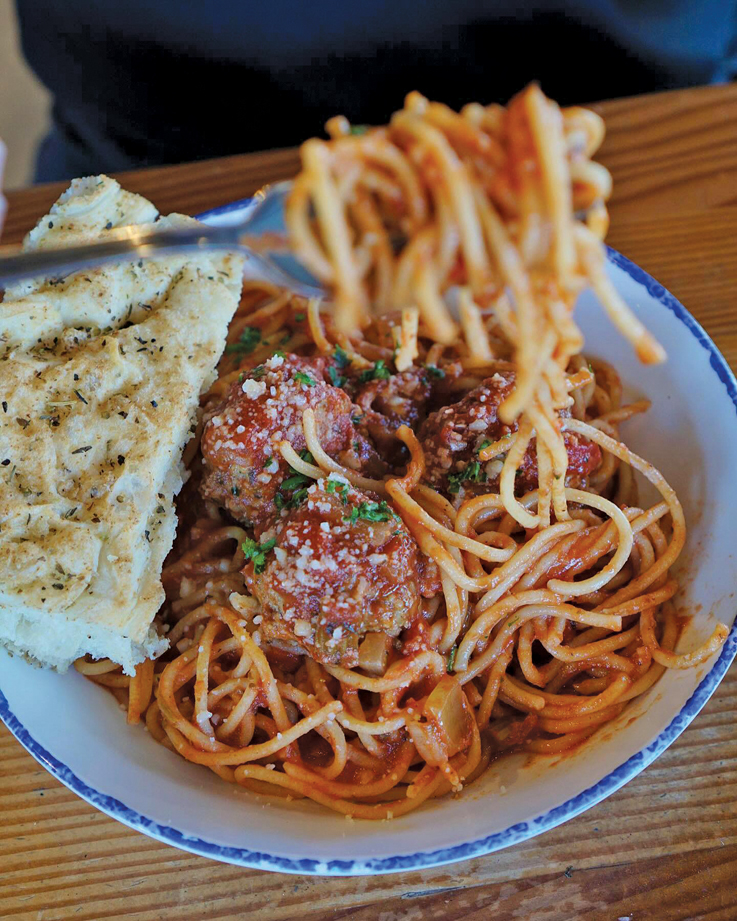 a plate of spaghetti and meat sauce, the noodles being twirled on a fork