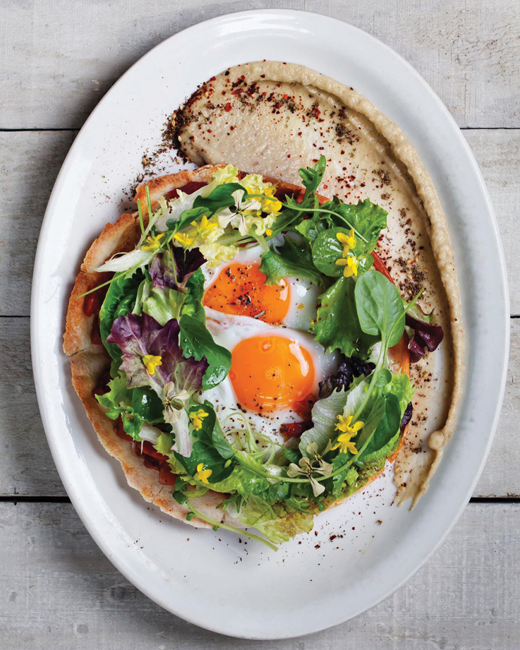 plate of eggs and hummus. on a table