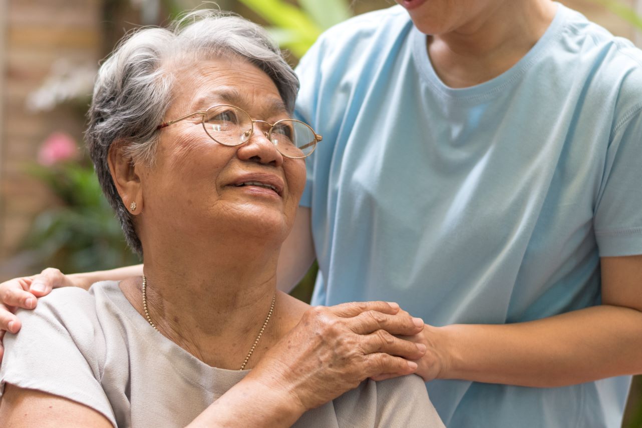 Nurse assisting elderly woman.