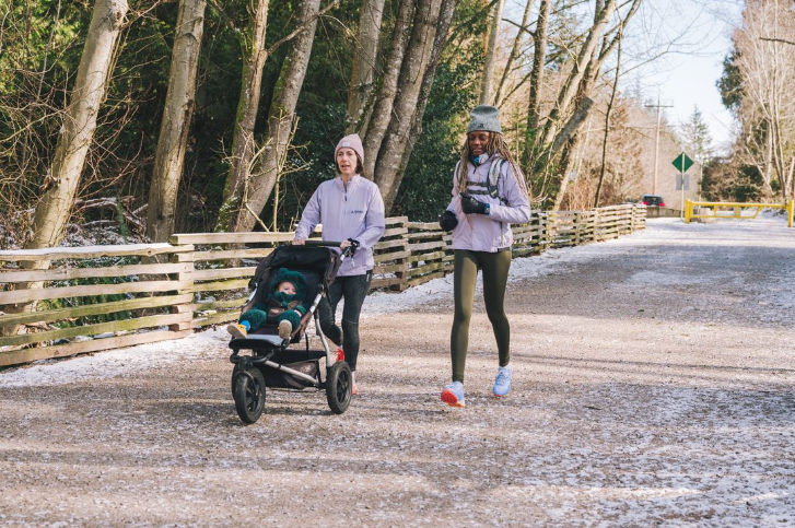 two women and a stroller on a trail, jogging