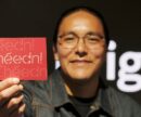 Leo Vicenti holding a red postcard printed with a custom type design that reads "Ihéédn!"